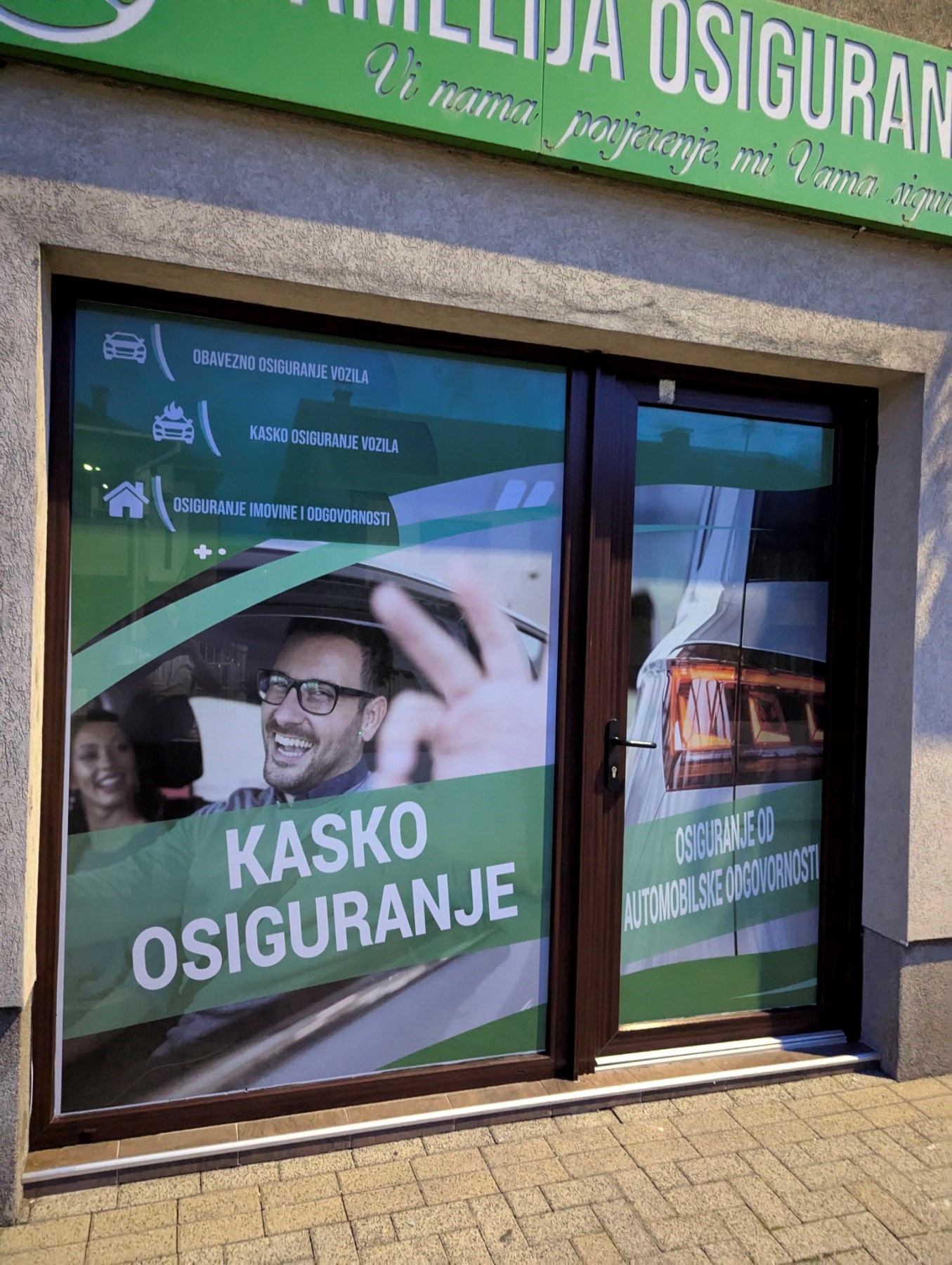 Oslikan izlog Camelija Osiguranja — folija sa fotografijom i porukama